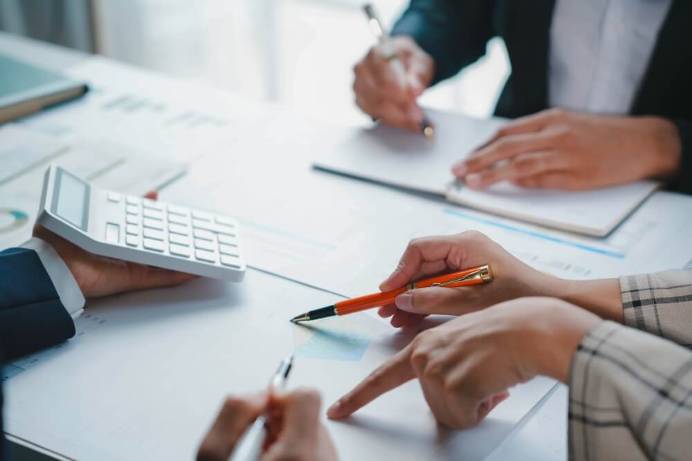 オレンジペンで書類にチェック作業